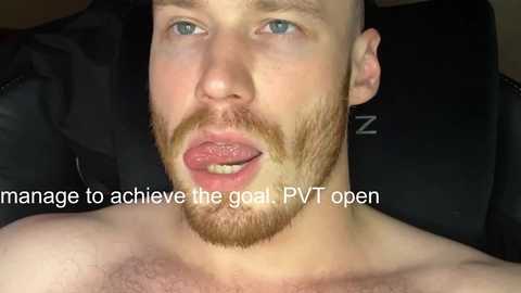 Media: Video of a fair-skinned, bearded, blue-eyed man with a bemused expression, wearing a black cap and a black T-shirt, with text overlay \"manage to achieve the goal PVT open.\