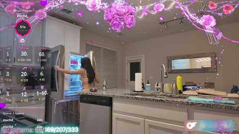 Media: Video of a modern kitchen with a woman opening a stainless steel fridge, surrounded by vibrant digital flower decorations and a virtual fitness tracker display.