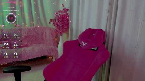 Media: A video of a pink gaming chair and a fluffy pink couch in a room with pink and green light, adorned with a pink flower arrangement and a digital display showing streaming stats.