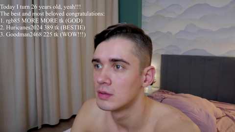 Media: A video of a young, shirtless man with short dark hair, blue eyes, and a toned physique, lying on a bed. Text overlays mention \"today I turn 22 years old, yeah!!\" in the background.