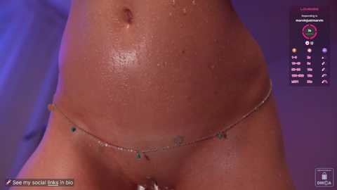 Media: Video of a light-skinned woman with a glistening, oiled abdomen, wearing a turquoise beaded chain thong. Background is a purple gradient.