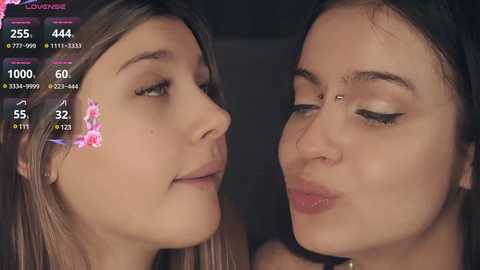 Media: Video of two young women with fair skin, long brown hair, and full lips. One has a floral crown, the other has eyeliner, in a close-up, intimate kiss.