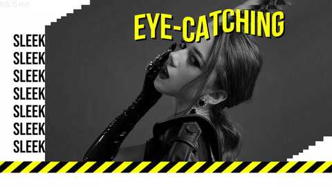 Media: A black-and-white video of a woman in a leather jacket, with dramatic eye makeup and a glossy black glove, set against a gray background. Bold yellow text reads \"EYE-CATCHING\" on the right.