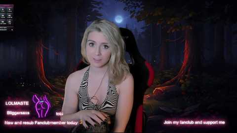 Media: A screenshot from a video game shows a blonde woman with a medium build and average breasts wearing a zebra-patterned halter top. She stands in a dark forest with a red-skinned demon behind her.