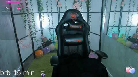 Media: Video of a gamer seated in a black Razer gaming chair in a brightly lit, plant-filled room with a VR headset on, viewed from behind.