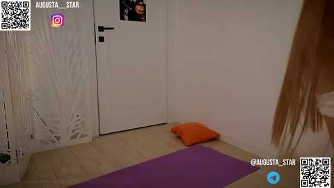 Media: A video of a minimalist bedroom with white walls, wooden floor, a white door, and a purple yoga mat. A small orange pillow sits on the floor, and a QR code is visible in the top left corner.