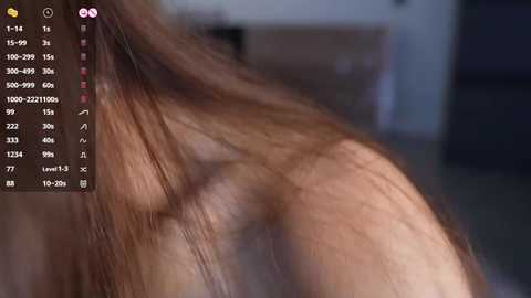 Media: A close-up video of a woman's shoulder and back, showing light brown skin and long brown hair. The background is blurred, possibly a bedroom with dark furniture. A digital screen on the left displays a list of numerical data.