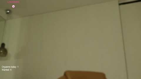 Media: Video of a dimly lit room with beige walls, featuring a brown leather chair and a modern, cylindrical lamp hanging from the ceiling. Text in the corner reads \"Oggy and the Cockroaches\" and \"Wanted!\