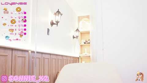 Media: This is a screenshot from a video game, featuring a minimalist, modern bathroom with light wood paneling, a cream-colored sink, and two black lantern-style wall sconces. The game interface includes a menu with icons and text in pink and white.