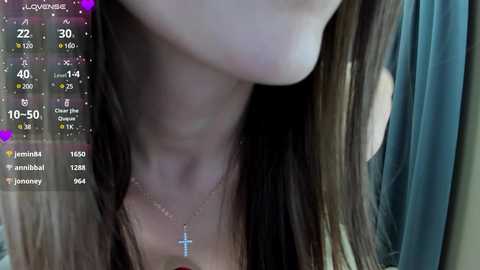 Media: Video of a woman with long brown hair, wearing a cross necklace, partially visible face, and a virtual health app overlay showing statistics.