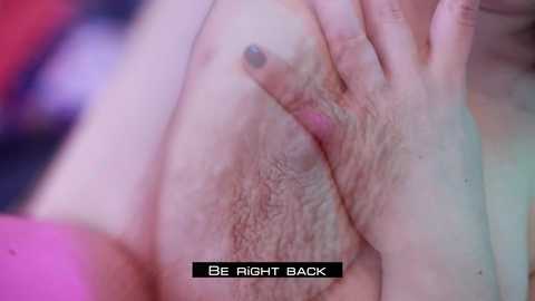 Media: Video of a close-up of a person's pubic area with a hand pressing down on the pubic hair, featuring a black text overlay reading \"BE RIGHT BACK.\