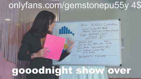 Media: Video of a woman with long black hair, dressed in a black suit, presenting a whiteboard with a graph and text, titled \"Your Portfolio Distribution,\" in an office setting.