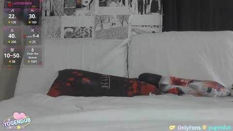 Media: Video of a woman in a red and white dress lying on a white bed, surrounded by black-and-white framed photos.