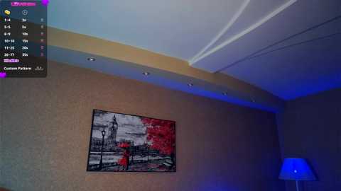 Media: Video of a beige-walled room with a large black-and-white framed photo of a red tree and a bench. The room is dimly lit with blue accents, and a modern white lamp is visible in the right corner.