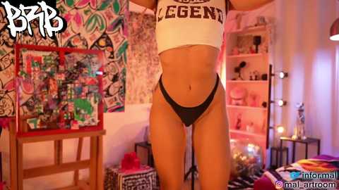 Media: Video of a fit woman in a white crop top and black panties, standing in a colorful, graffiti-covered room with shelves, a bed, and a desk.