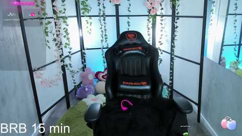 Media: A video of a gaming setup with a black Razer gaming chair, plush toys, and a VR headset, surrounded by hanging pink flowers and a soft green rug, with a 15-minute timer displayed.