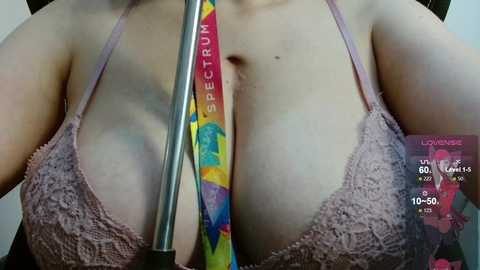 Media: A close-up video of a woman's chest in a pink lace bra, with a rainbow-colored dildo and a \"Spectra\" toy, and a digital graph overlay showing sexual performance metrics.