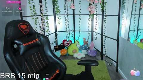 Media: A video of a gamer in a cozy room with a black gaming chair, plush toys, and pastel-colored hanging plants, viewed through a VR headset.