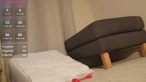 Media: Video of a beige bed with a brown headboard, white sheets, and wooden legs, set against a beige wall. A digital overlay shows statistics and options, suggesting a virtual reality or gaming context.