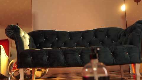 Media: A video of a dark green, tufted velvet sofa with high arms, set in a warmly lit room with wooden floors and a modern, minimalist decor.