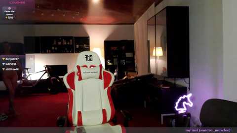 Media: Video of a modern, dimly lit living room featuring a white and red gaming chair with a \"BR\" logo, a plush red carpet, and a neon horse silhouette on a wall.