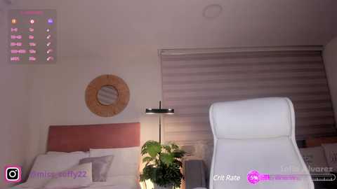 Media: Video of a modern, minimalist bedroom with a white leather chaise lounge, wooden headboard, circular mirror, striped wallpaper, and a potted plant.