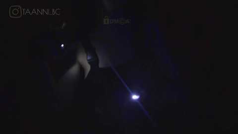 Media: A dimly lit video of a person with a hooded figure, partially obscured, standing in a dark, possibly urban, environment. The image is grainy and low-resolution, with a watermark in the top left corner.