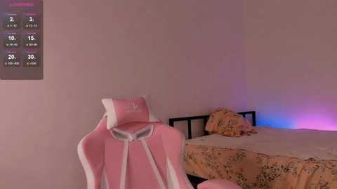 A video of a pink gaming chair in a minimalist bedroom with a calendar, a bed with floral sheets, and a purple light.