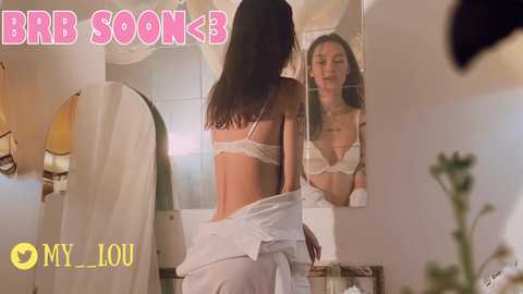 Media: Video of a woman in white lingerie, reflected in a mirror, in a modern bathroom with a beige towel and a plant. Text: \"BBB S0K3,\" \"MY LOU.\