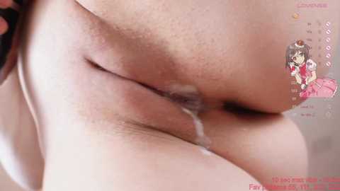 Media: Video of a close-up of a person's shaved vulva, with a small amount of fluid visible, taken from a side angle. Background features a blurred, pale-colored surface.