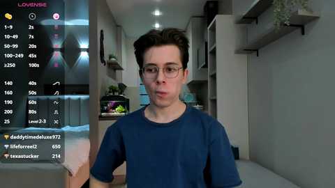 Media: A video of a young man with glasses and dark hair in a blue shirt, standing in a modern, minimalist kitchen.