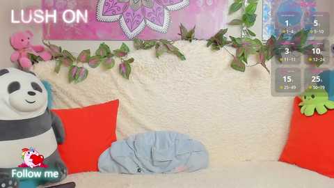 Media: Video of a cozy room with plush toys, a soft blanket, and green plants. The background features a mandala wall hanging. \"LUSH ON\" watermark at top left.