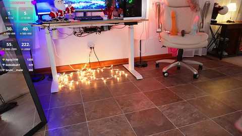 Media: Video of a gaming room with a white gaming chair, a desk with a computer monitor, a gaming console, and a glowing string of fairy lights on the floor, with a visible \"FPS\" rating in the corner.