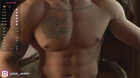 Media: A video of a shirtless, muscular man with a large, detailed lion tattoo on his chest, taken indoors, with a \"LOVE\" tattoo above it.