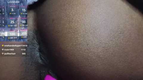 Media: Video of a close-up of a dark-skinned person's buttocks, with a zoomed-in shot of the skin texture and a visible mole. On the left side, a digital screen shows workout statistics and a progress bar.