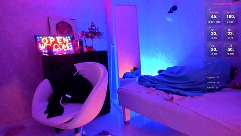 Media: A video of a modern, neon-lit bedroom with a white chair, black cat, \"OPEN ME\" sign, and a bed with blue sheets, featuring a digital temperature gauge.