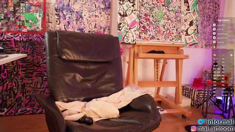 Media: Video of a dark leather recliner with a white blanket, set in a room with vibrant graffiti-covered walls and a wooden table.