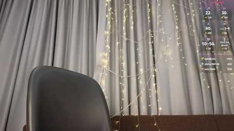 Media: Video of a cozy room with a black chair, white curtains, and a glowing string of fairy lights. A digital display shows the weather forecast, with temperatures of 19\u00b0C and 50% humidity.