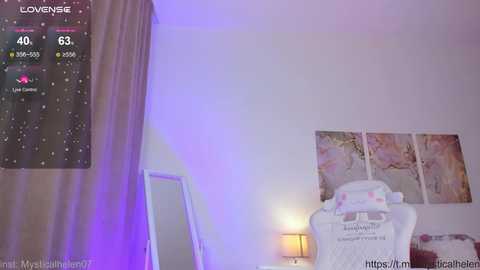 Media: Video of a bedroom with a digital clock on the wall, a white chair with a pink blanket, and a framed painting.