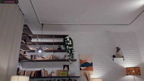 A video of a modern living room with white brick walls, wooden shelves, and a cozy atmosphere.