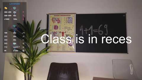 Media: Video of a classroom wall with a colorful anatomy chart, a blackboard with math equations, a green potted plant, and a whiteboard in the background. Text overlays read \"Class is in recess.\