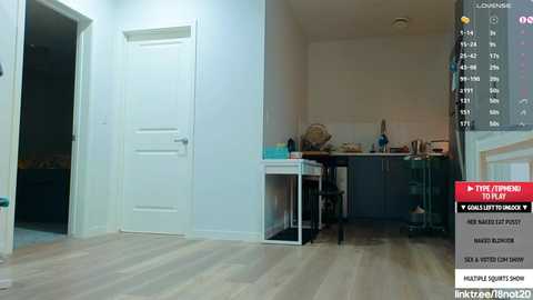 Media: Video of a minimalist, well-lit kitchen with white walls and wooden floors, featuring a modern, white dining table and chairs, a white door, and a black counter with utensils.