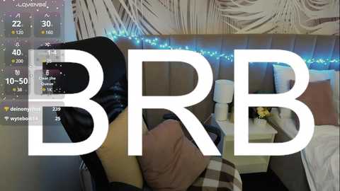 Media: Video of a modern bedroom with a white, tufted headboard, blue string lights, and a \"BBB\" logo overlay.