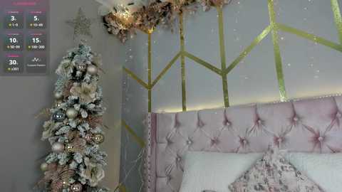 Media: Video of a chic, pastel-colored living room with a tall, decorated Christmas tree and a tufted, pink headboard. The room features geometric, gold accents and a soft, muted color palette.