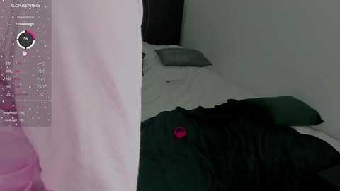 Media: A video of a dimly lit bedroom with a white bed sheet and dark green blanket, showing a person sleeping. A pink digital clock is visible on the left, and a window with white curtains is partially open.