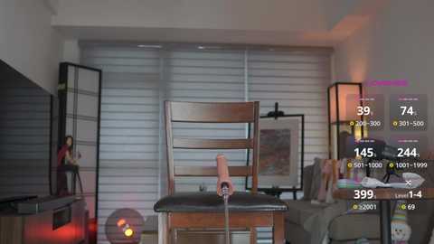 Media: A video of a modern, dimly lit living room with a wooden chair and a man in a red shirt standing near a large flat-screen TV.