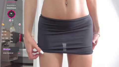 Media: A video of a woman's midsection in a dark gray mini-skirt, pulling it down, with a digital overlay displaying her stats and a chat bubble.