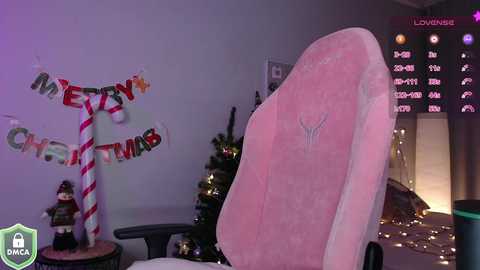 Media: A video of a pink gaming chair with a \"Merry Christmas\" banner and a decorated Christmas tree, set in a dimly lit room with a live-streaming screen in the background.