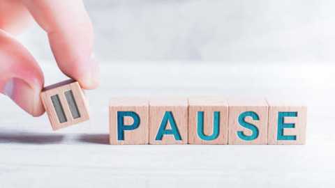 Media: Video of a hand holding a wooden block with the letter \"P\" in teal, standing on a wooden block spelling \"PAUSE\" on a light wooden surface.