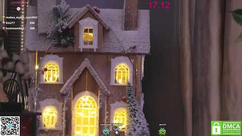 Media: Video of a cozy, snow-covered wooden house with glowing yellow windows, set against a dark, wintry background.